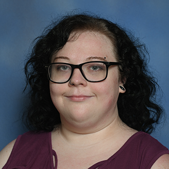 a person with glasses and a purple shirt