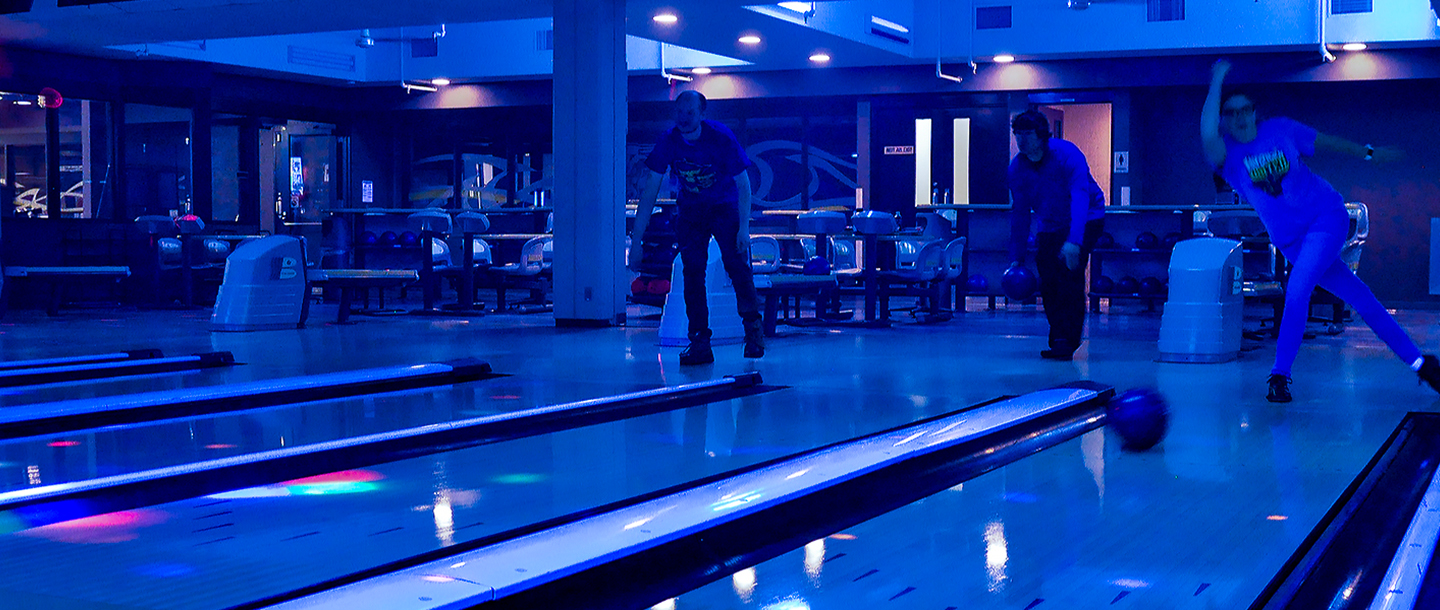 Three students bowling in Bullpen Bowling Alley