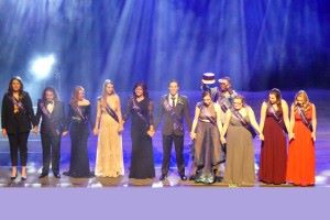 Members of the Homecoming Royalty Court of 2019 posing for a photo on the stage inside campus wearing purple sashes