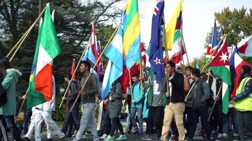 International students holding their country's flag in the flag parade of Mankato