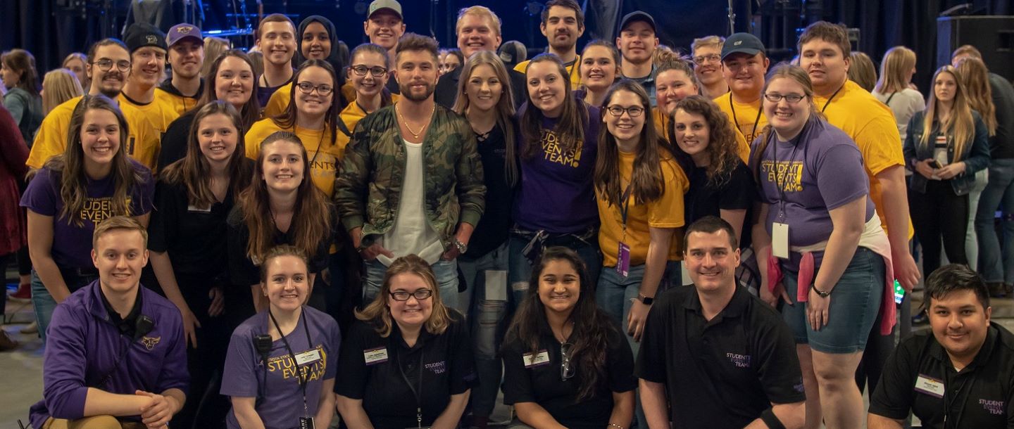 student events team taking group picture with the band