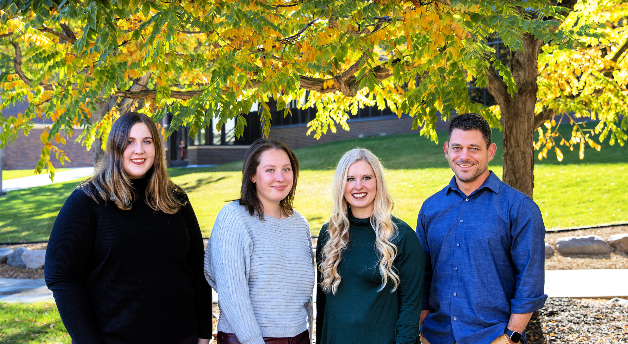 a group of people standing under a tree