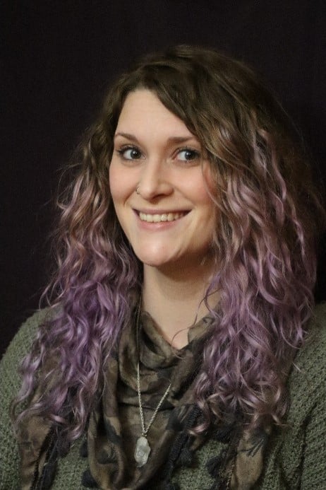 a person with long hair smiling