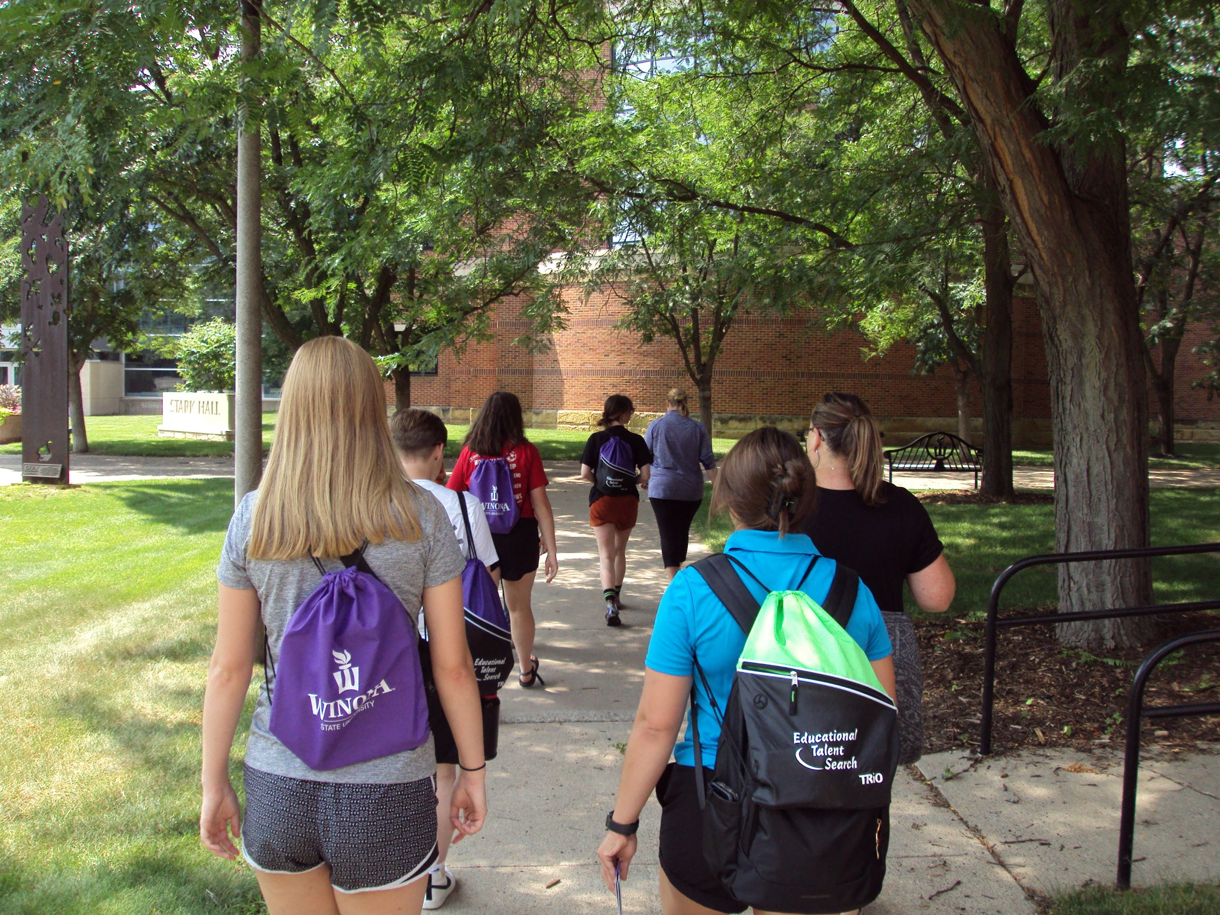 a group of people walking on a sidewalk