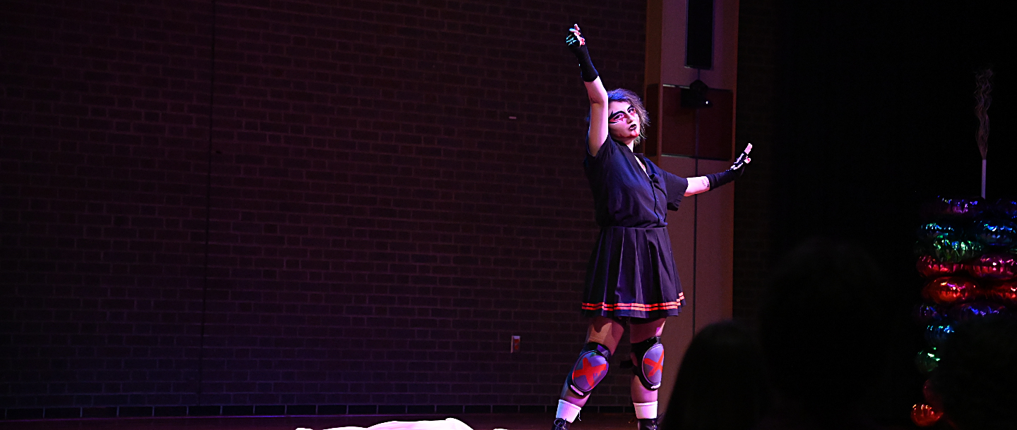 a person in a black dress and knee pads holding her arms up