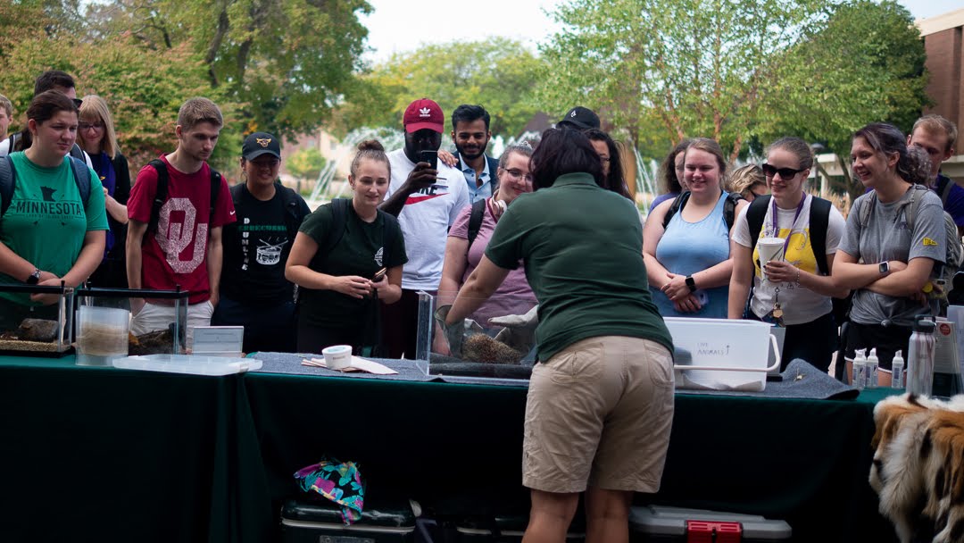 a group of people standing around a table