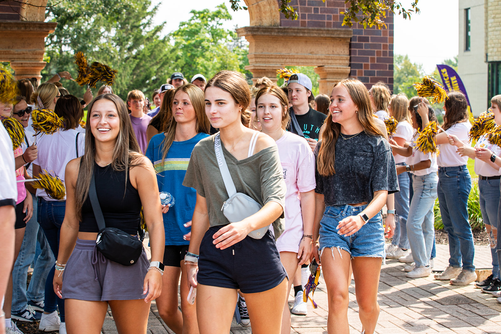 a group of people walking on a brick sidewalk