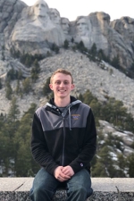 Hunter Herber posing for a photo with Mount Rushmore in the background