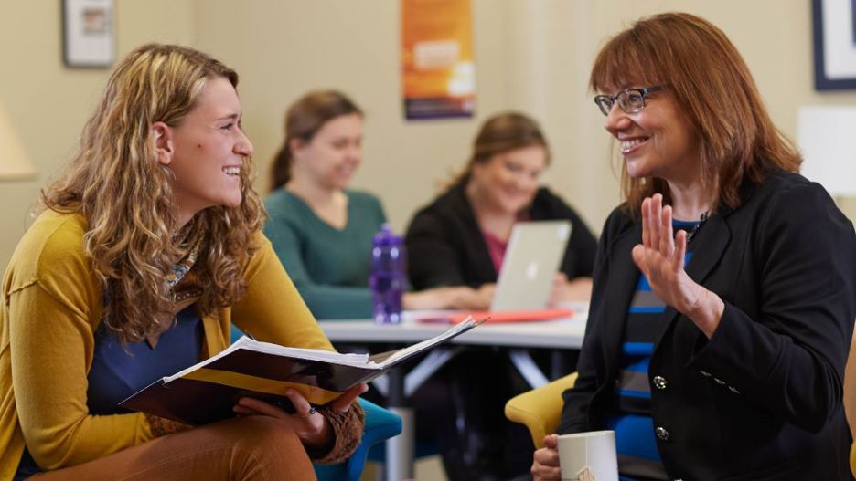 Student Julia Hamann sitting down with a professor having a discussion