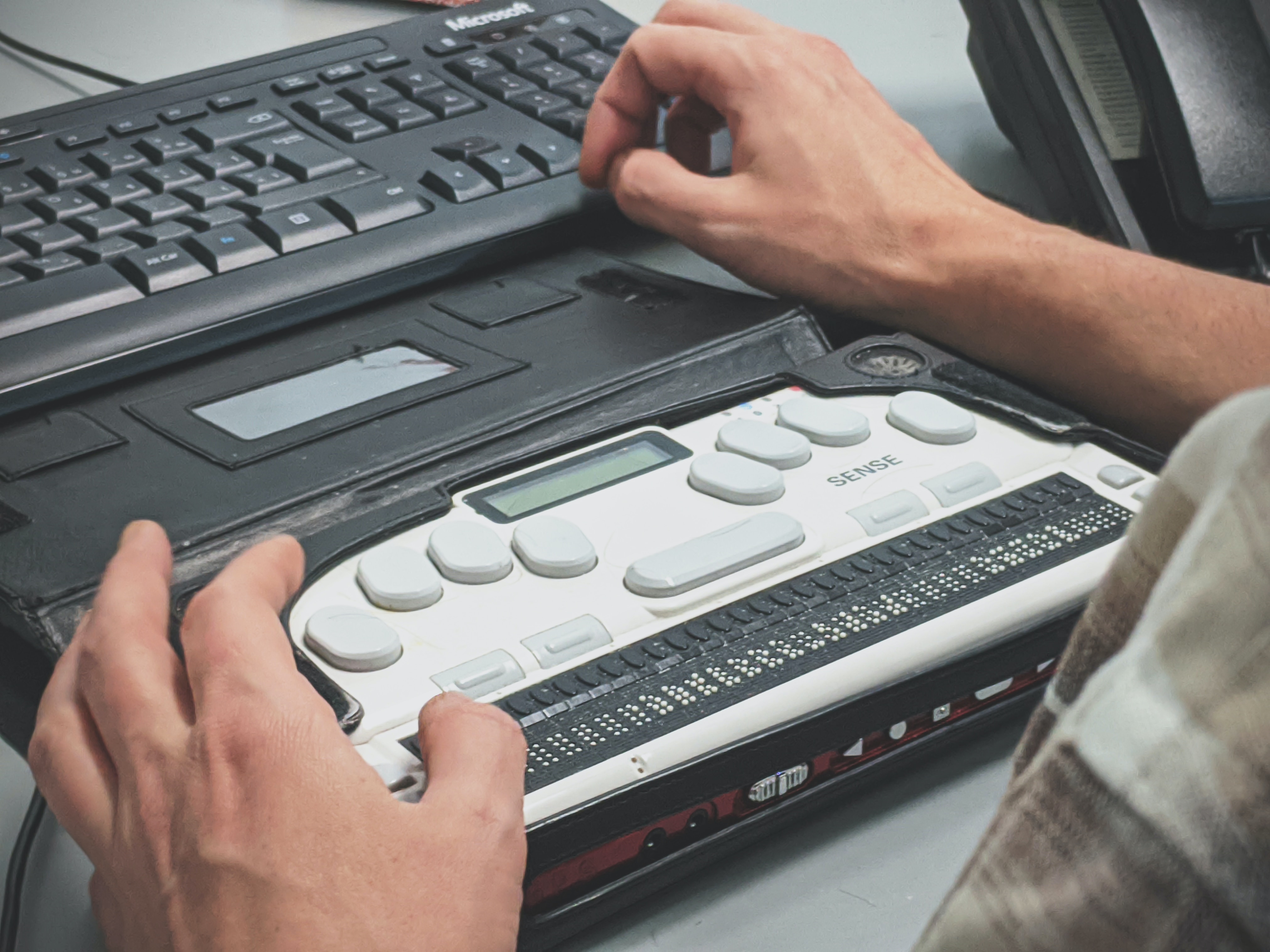 a person's hands on a refreshable braille display