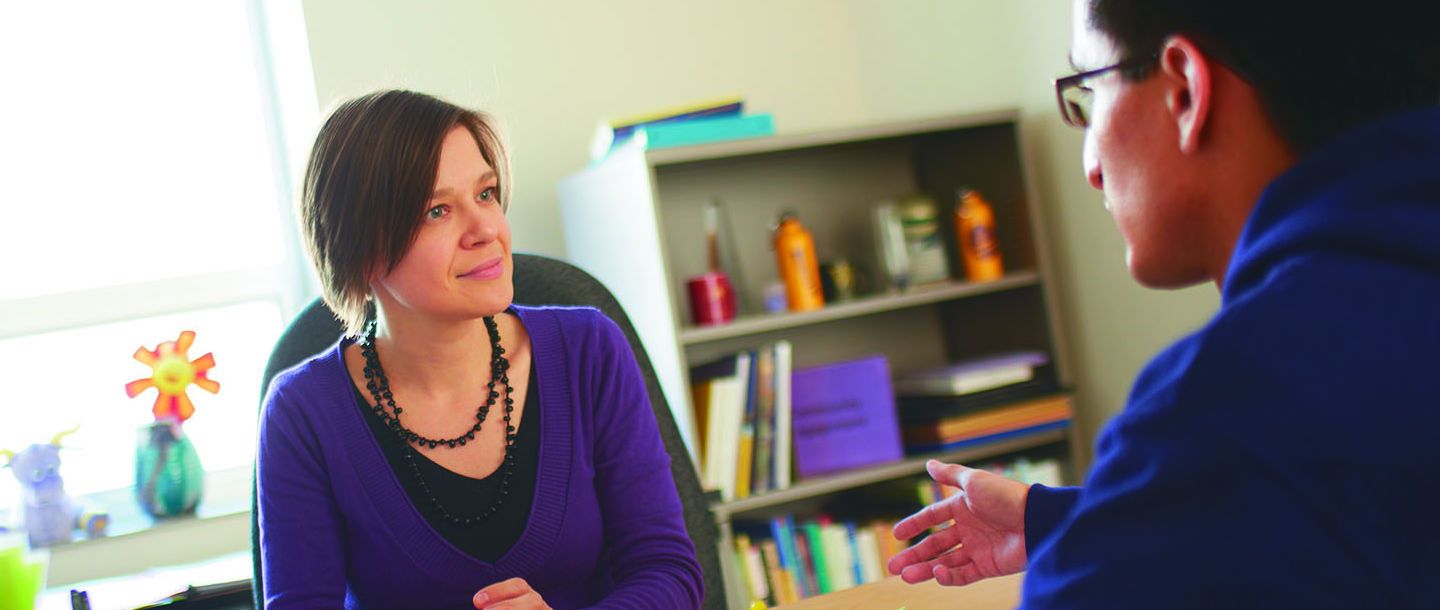 A student talking with an advisor in their office