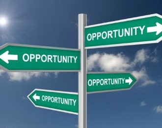 Road signs with the word Opportunity and an arrow pointing in different directions with clouds and blue sky in the background