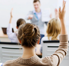 Students in the classroom raising their hands