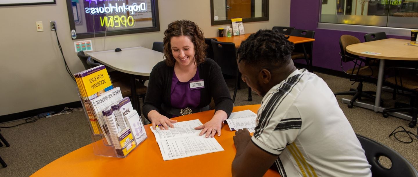 Staff guiding a student with career resources at the career development center