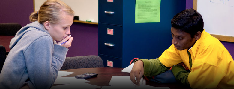 Two students studying together at a table in the classroom