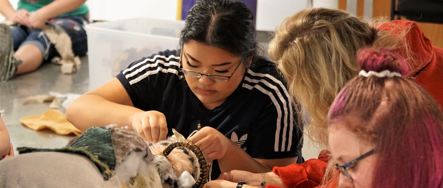 Three students working on an physical art model