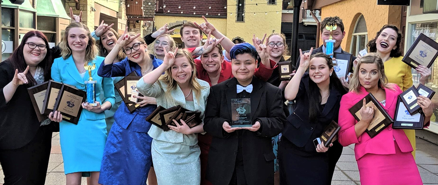 Students of Arts & Humanities posing with their recognition awards and trophies