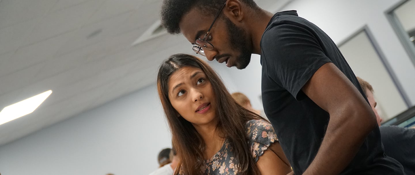 Female student looking at her male colleaguet