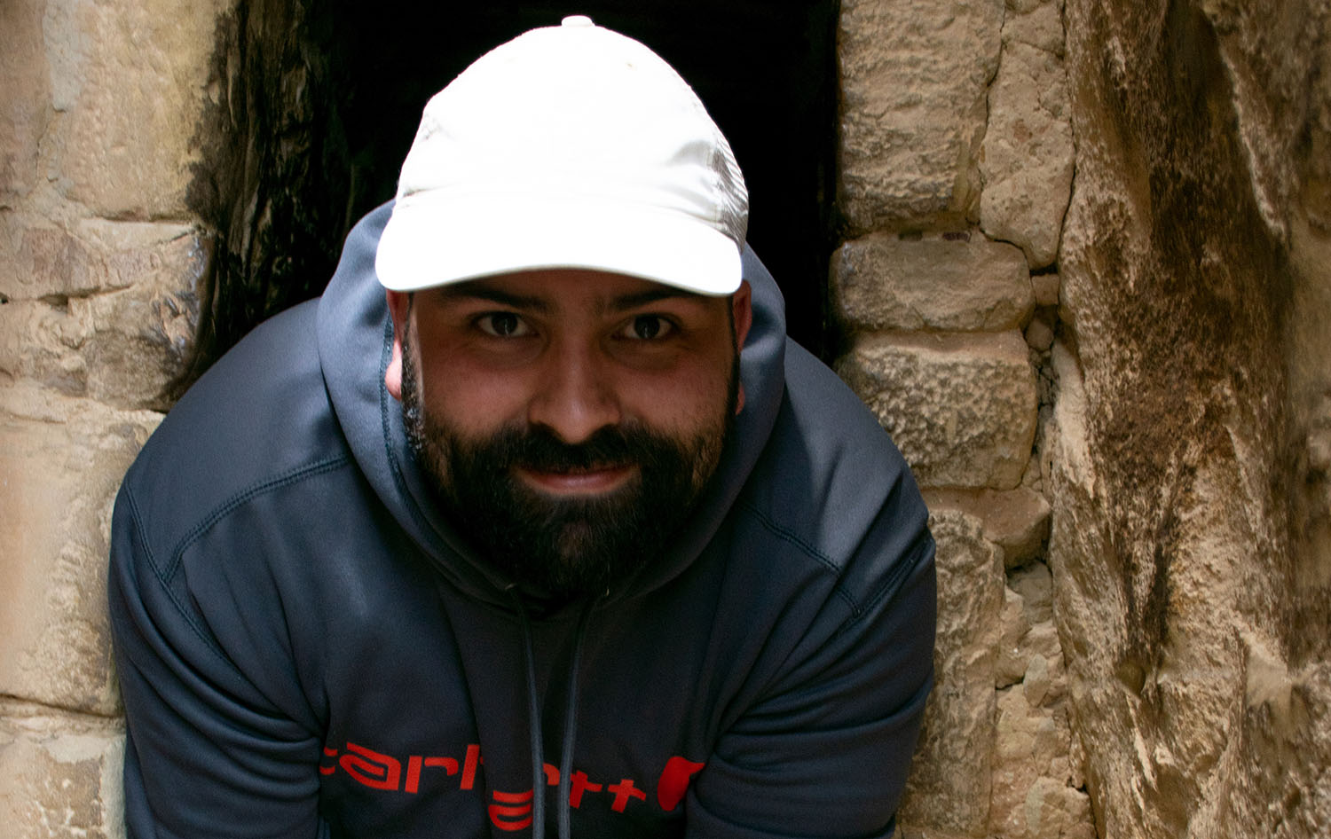 a person wearing a white hat and a hoodie