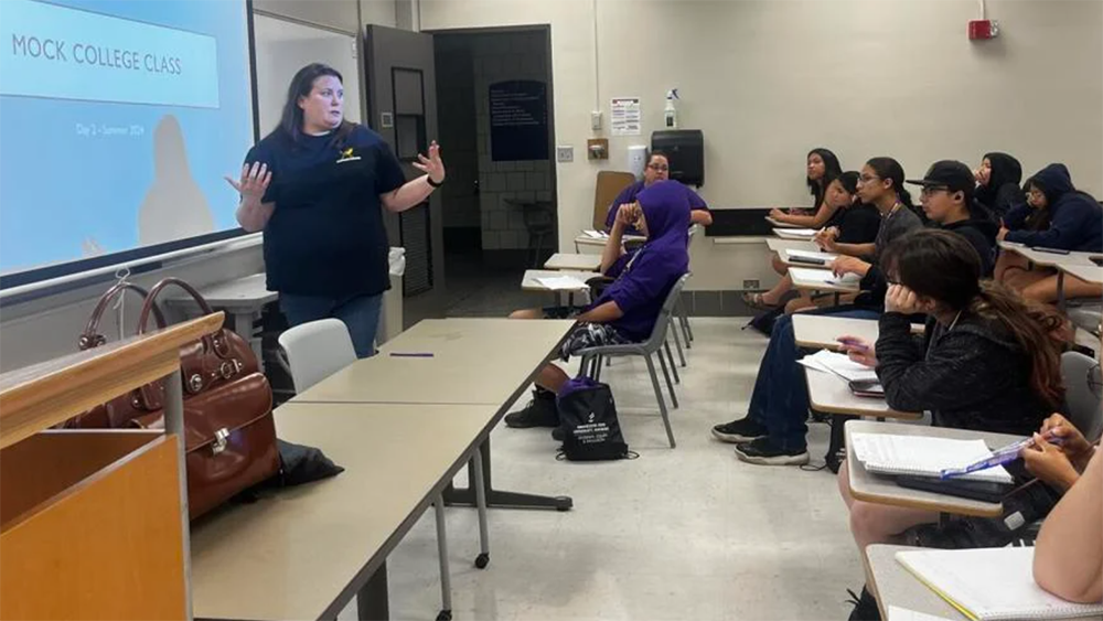 Professor Chelsea Mead teaching students at desks.