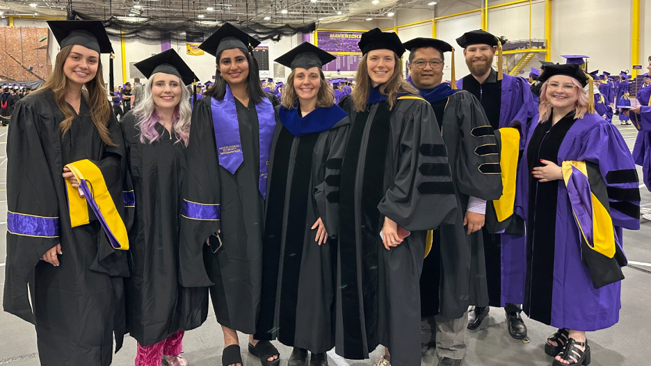 a group of people in graduation gowns and caps