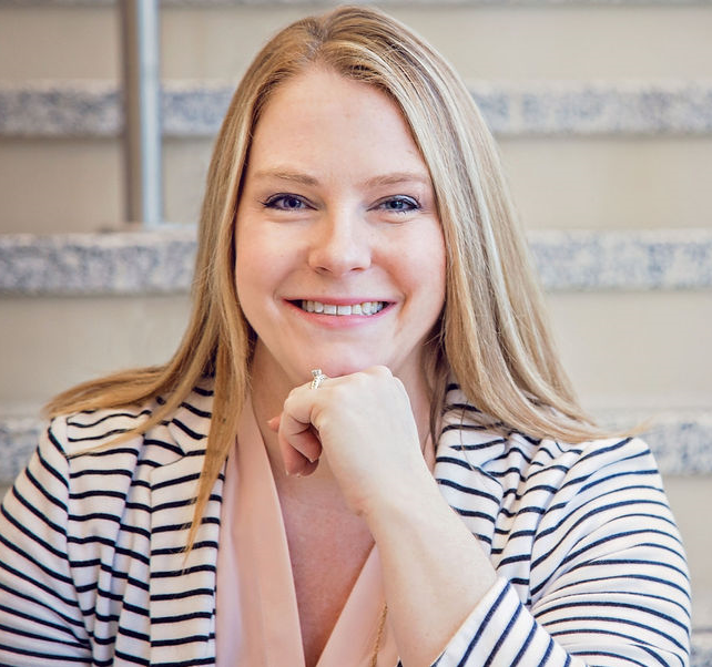 a person smiling with her hand on her chin