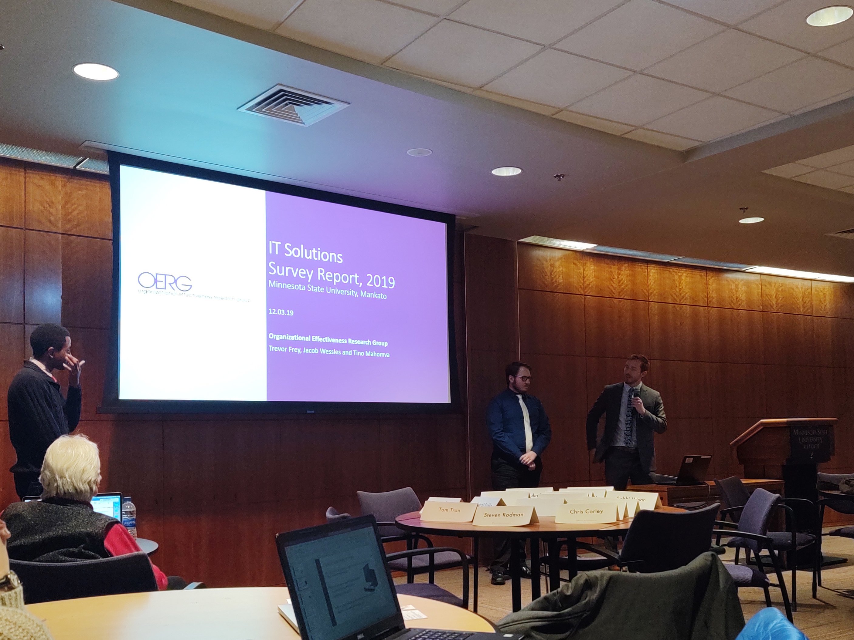 a group of people in a room with a projector screen