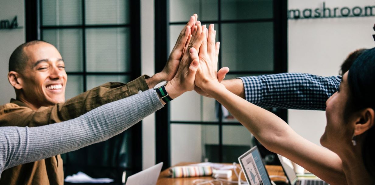 four people high-fiving each other