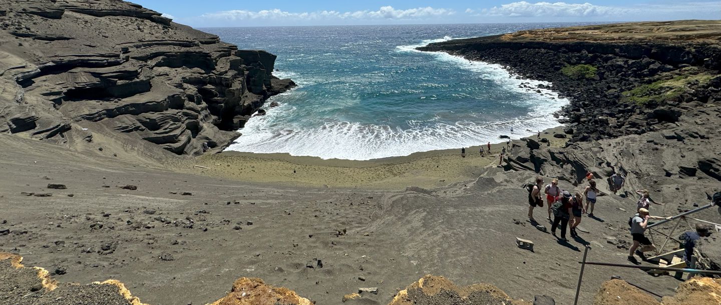 Students exploring the Papokolea Green Sand Beach in Hawaii on a sunny day