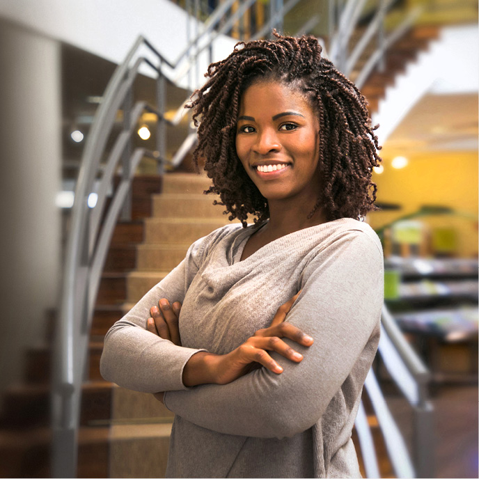 Woman holding books smiling at the camera