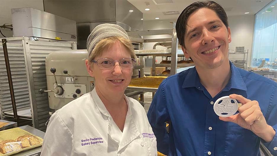 Bakery Supervisor Becky Fredericks and Dining Services Operations Director Lee Hengescht posing with smiles in the campus bakery