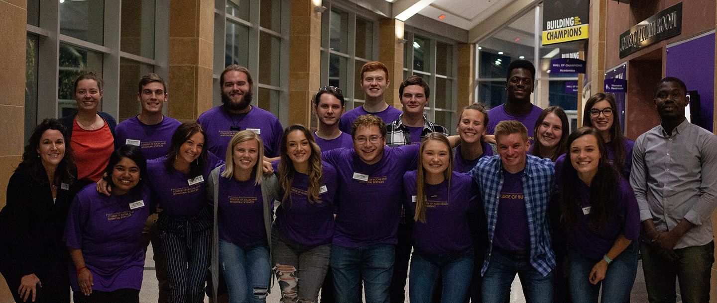 A group of students posing in the hall of the Taylor Center