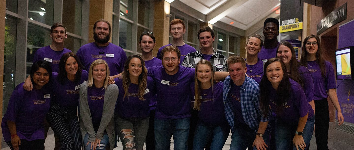 A group of students posing for a picture in the hall of the Taylor Center