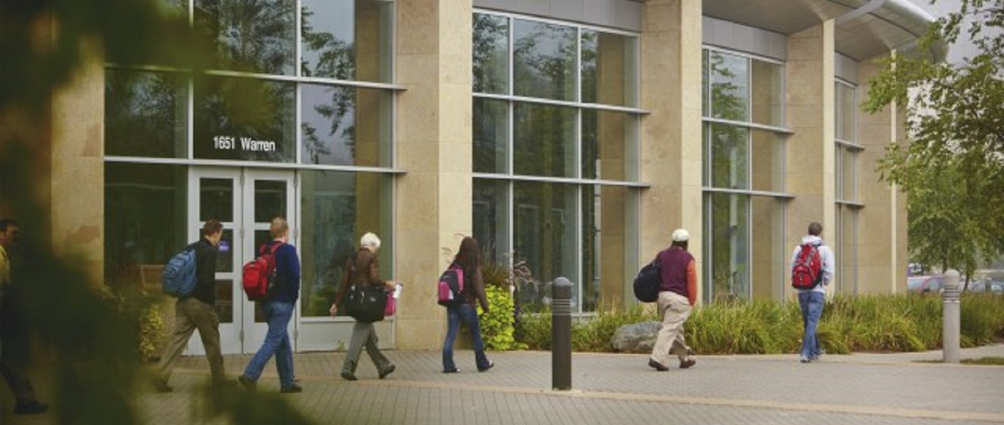 Seven poeple walking outside by the Minnesota State University Taylor Center building