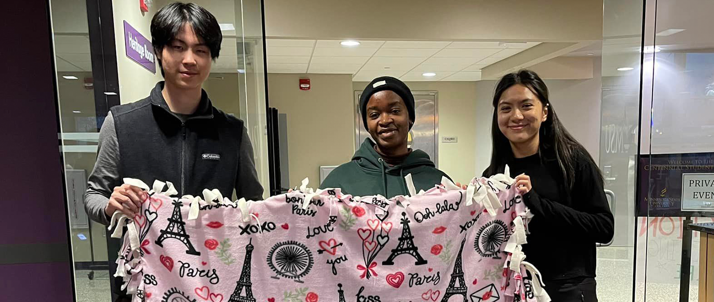 a group of people holding a blanket