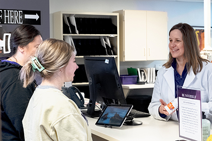 two students at counter with Pharmacist