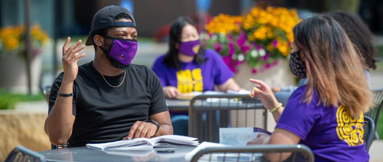 two student with mask having discussion