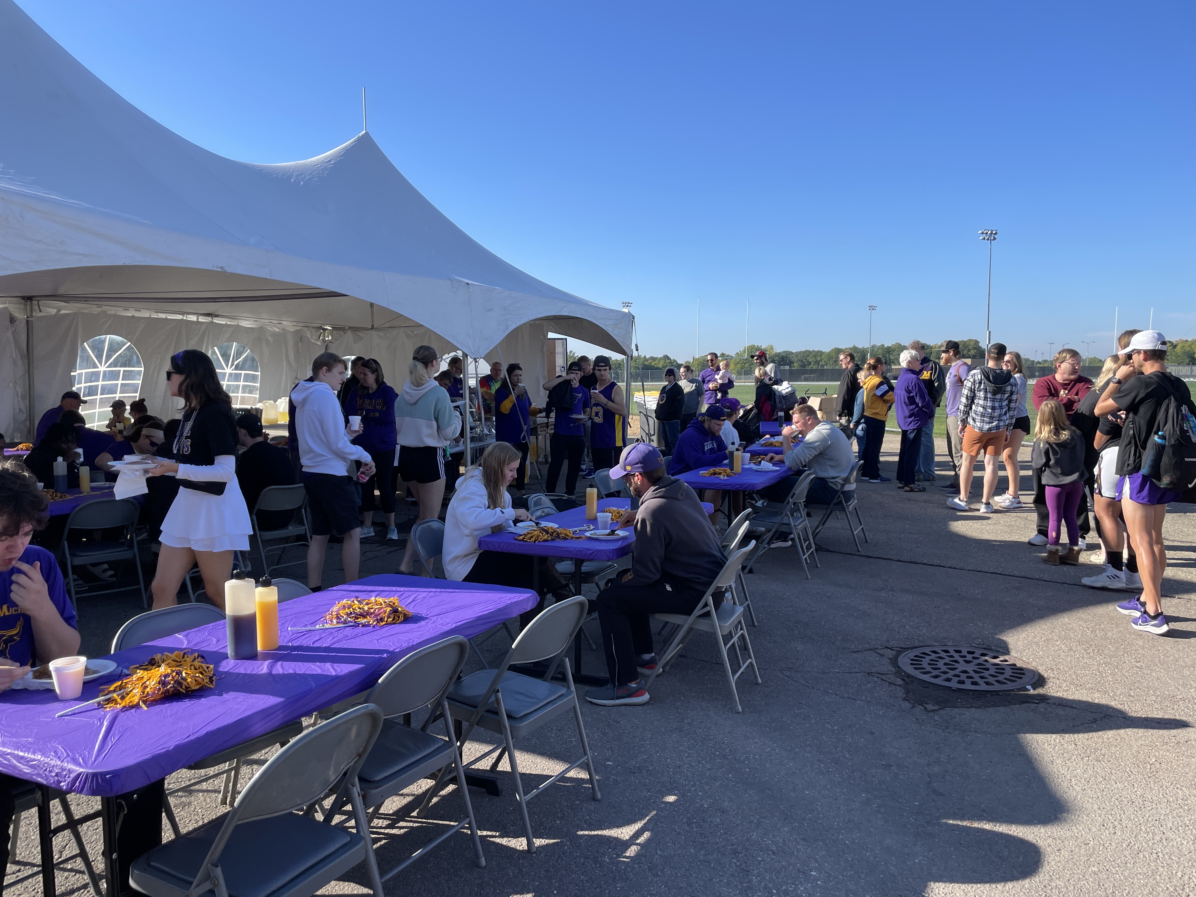 a group of people at tables with food and drinks