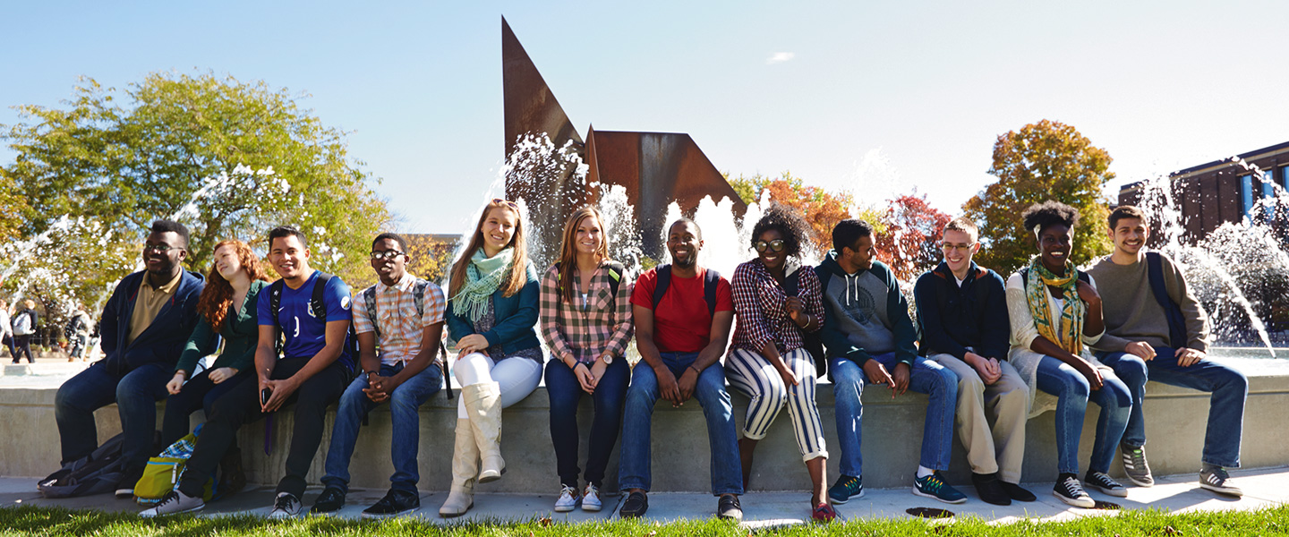 Students sitting on edge of fountain