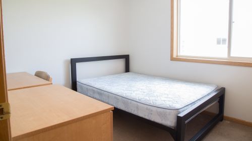 3-person apartment bedroom with desk and bed by the window