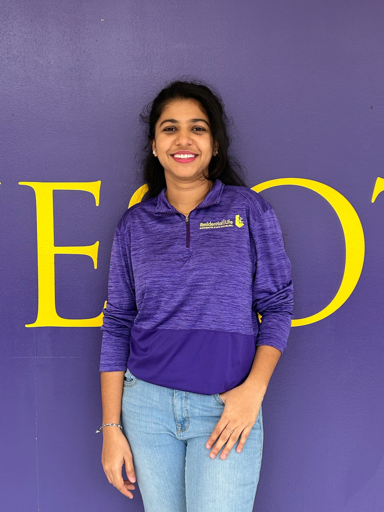 a person standing in front of a purple wall