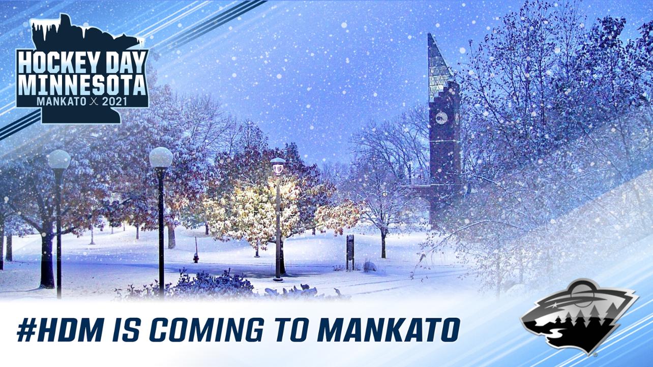 a snow covered park with trees and a clock tower