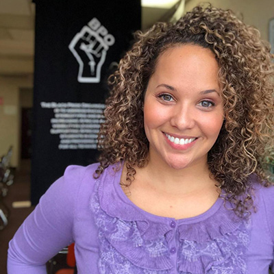 a person with curly hair smiling