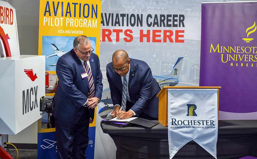 a person in suit signing a document