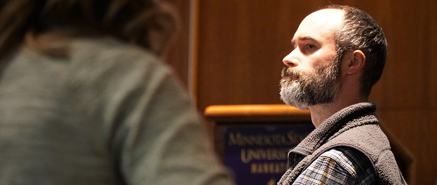 Close up of a male faculty member in a room at a meeting